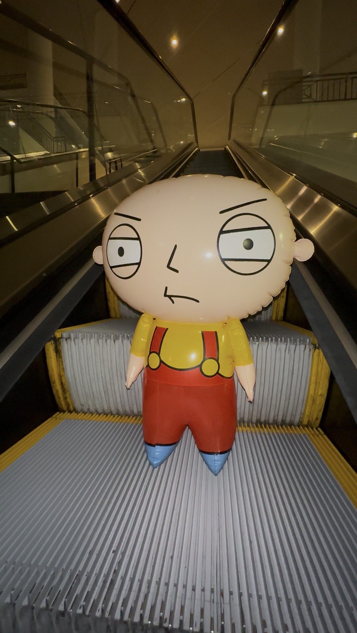 Inflatable balloon baby riding an escalator